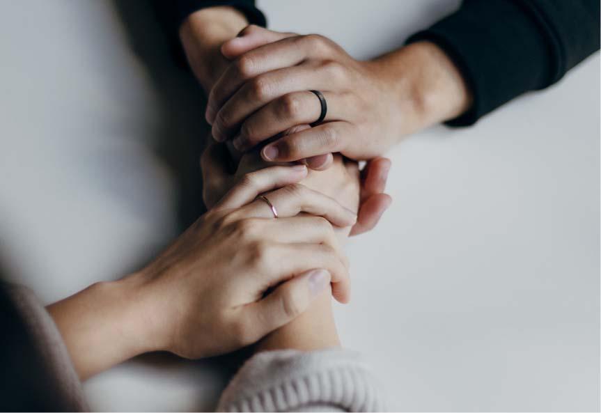 Image of a married couple's hands holding each others' with both hands